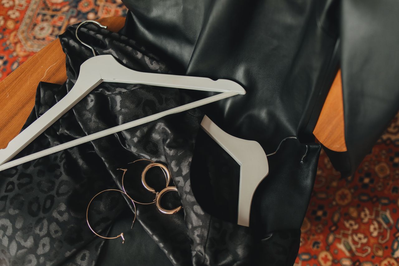 Elegant fashion arrangement with a black dress, metallic earrings, and more, perfect for chic styling.