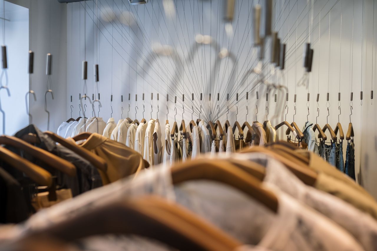 A diverse collection of clothes neatly arranged on hangers in a trendy boutique setting.